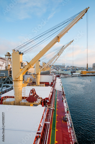 Dry cargo deck covered with a thin layer of snow
Bulk carrier at the mooring wall in the seaport, awaiting loading operations
