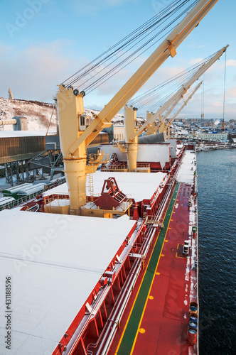 Dry cargo deck covered with a thin layer of snow
Bulk carrier at the mooring wall in the seaport, awaiting loading operations