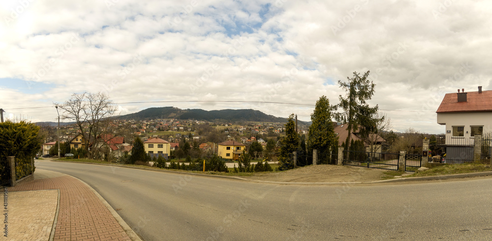 Limanowa, South Poland: Panorama View of houses showing countryside life in polish village against polish mountains and dramatic clouds. Limanowa, South Poland: Panorama View of houses showing countryside life in polish village against polish mountains and dramatic clouds.
