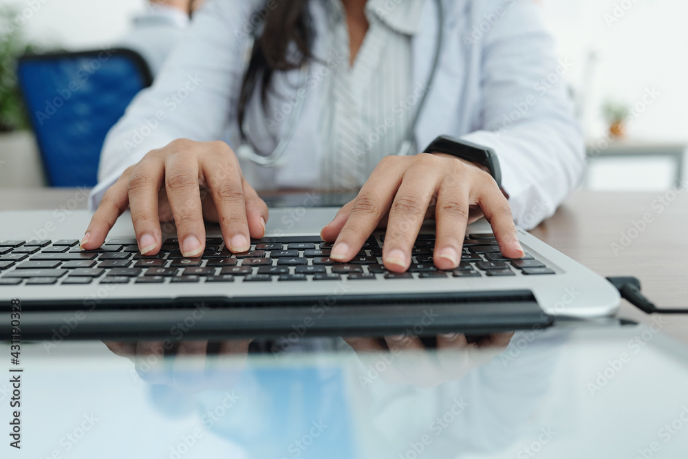 Close-up image of female general practitioner working on computer and entering patients data and diagnosis Close-up image of female general practitioner working on computer and entering patients data and diagnosis