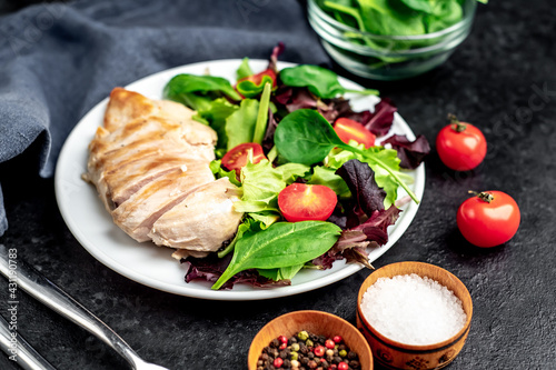 Chicken fillet with salad and spinach. Healthy food on stone background