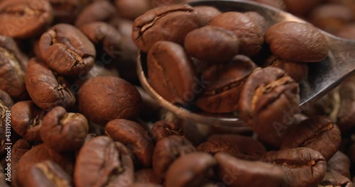 Close up of organic roasted coffee beans that are moved around with a small silver-colored spoon shot at 120 fps