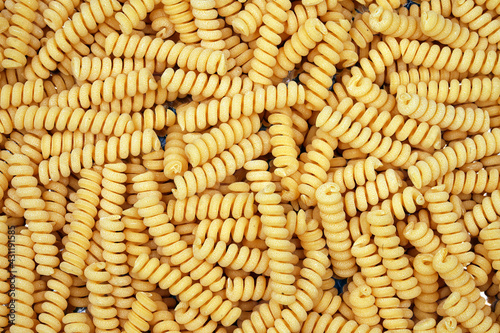 Spiral pasta background. Close-up of raw spaghetti, italian food. Garnish. Flour products. Paste. 