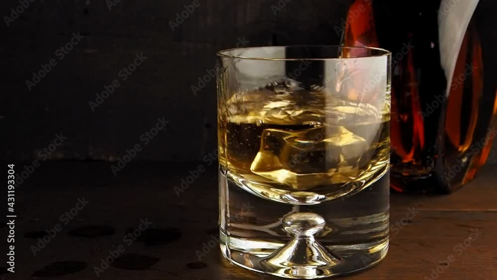Ice cube splash in whisky glass, slow motion Ice cube splash in whisky glass, slow motion
