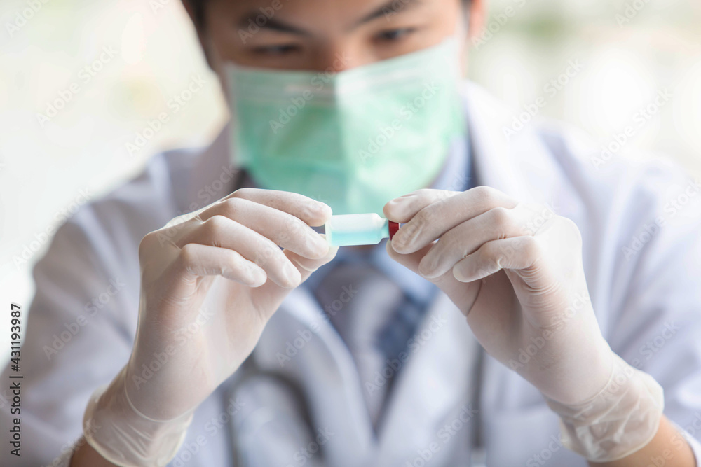 The doctor is testing a sample of biological tubes contaminated by Corona-virus Covid 19 and searching for a vaccine or Syrup against the virus. In the laboratory and film samples of infected lung The doctor is testing a sample of biological tubes contaminated by Corona-virus Covid 19 and searching for a vaccine or Syrup against the virus. In the laboratory and film samples of infected lung