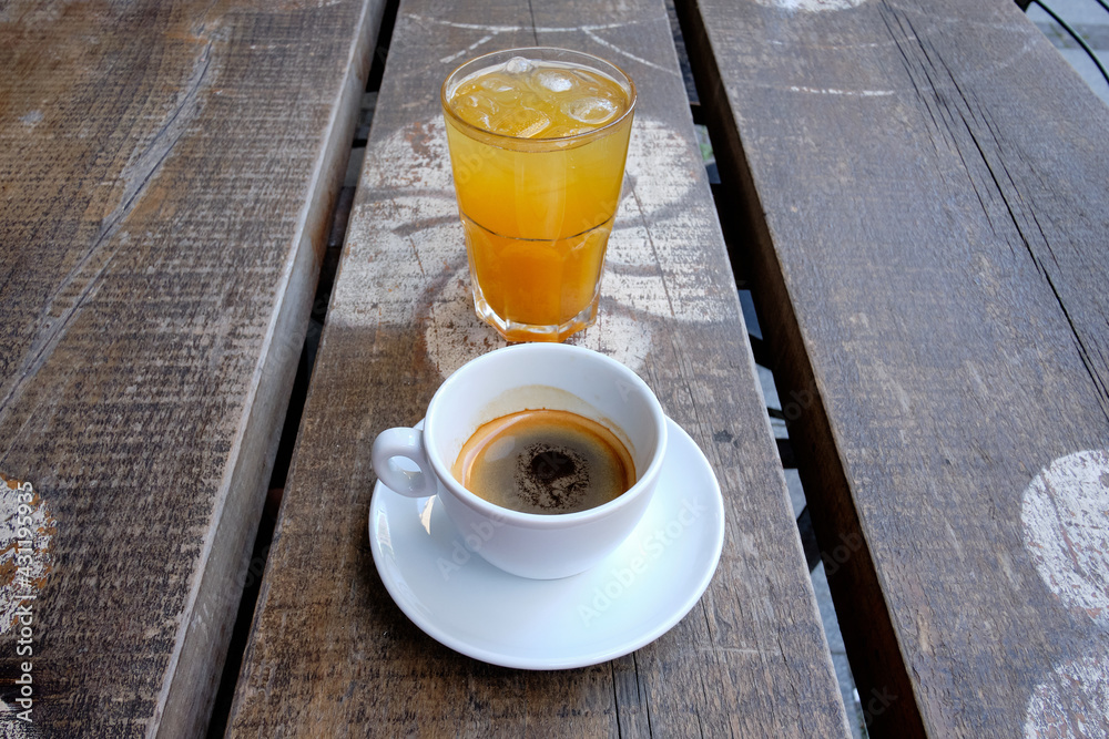 Cup of coffee and a glass of fresh orange juice on a wooden board - obrazy, fototapety, plakaty 