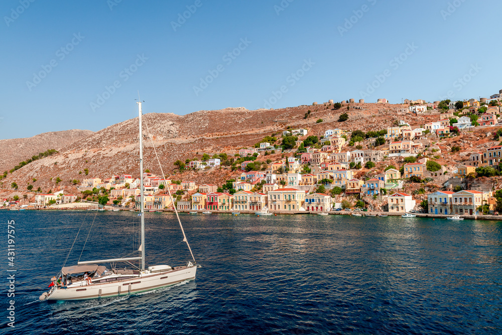A yacht approaches Symi, a tiny island of Dodecanese, Greece, that amazes visitors with the calm atmosphere and its fabulous architecture.