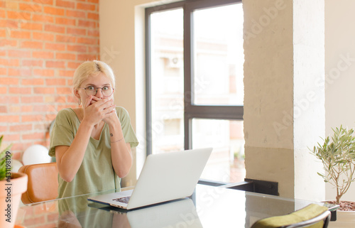 pretty student covering mouth with hands with a shocked, surprised expression, keeping a secret or saying oops photo