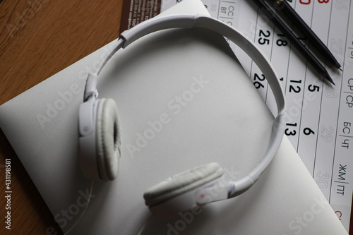 Business lifestyle 
Headphones on laptop
Pen and pencil on calendar for meeting marks 
