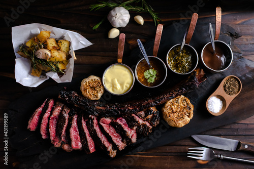 Photos tomahawk steak on a wooden cutting board placed on a wooden table