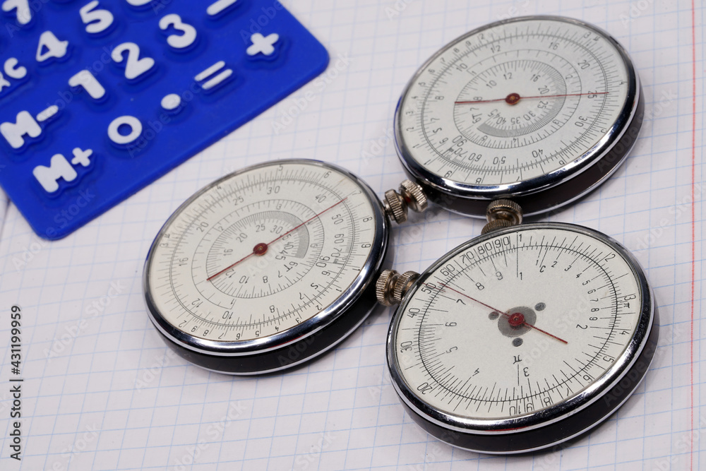 Logarithmic ruler closeup and colorful pencils on a white background. Vintage antique round slide ruler Calculator, felt-tip pens, office, calculating device. Maths. Mathematical. Measuring instrument Logarithmic ruler closeup and colorful pencils on a white background. Vintage antique round slide ruler Calculator, felt-tip pens, office, calculating device. Maths. Mathematical. Measuring instrument