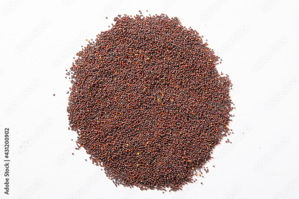 mustard seeds in the wooden scoop, isolated on white.Rai or brown mustard seeds