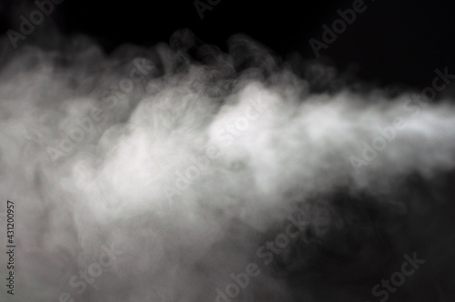 White fluffy clouds on a black background. Smoke. Clean fresh air. Steam.