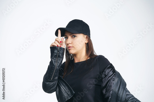 attractive girl in a black jacket and cap. photo session in the studio