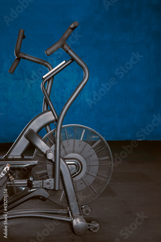 Bicicleta de Aire en gimnasio con piso de goma y fondo azul. Concepto de equipo de gimnasio