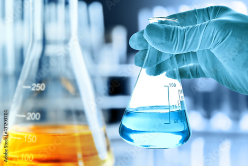 hand of scientist holding flask with lab glassware in chemical laboratory background, science laboratory research and development concept	
 photo