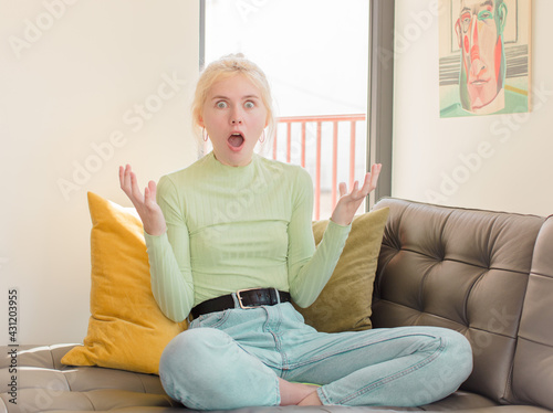 pretty woman open-mouthed and amazed, shocked and astonished with an unbelievable surprise photo
