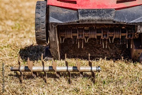 Lawn care - old grass removal and soil aeration with scarifier photo