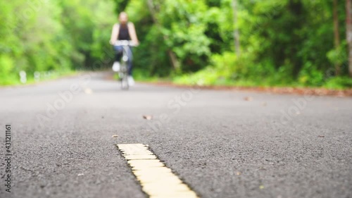 Wallpaper Mural Women are cycling road bike in the morning.She is on a forest road. Healthy lifestyle - people riding bicycles in city park. Urban biking - woman riding bike in natural road. Torontodigital.ca