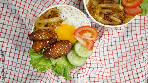 Healthy fresh rice bowl with tomato green cuisine and fried chicken wings on red squared cloth