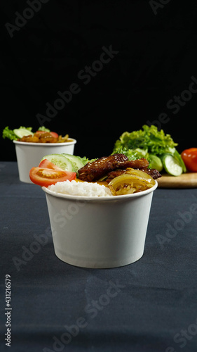 Healthy fresh rice bowls with tomato green cuisine and fried chicken wings in dark background