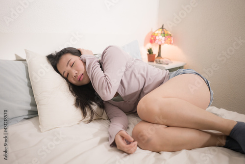 young Asian woman depressed - young beautiful and sad Chinese girl on bed with pillow feeling unhappy and broken heart suffering depression problem at home bedroom