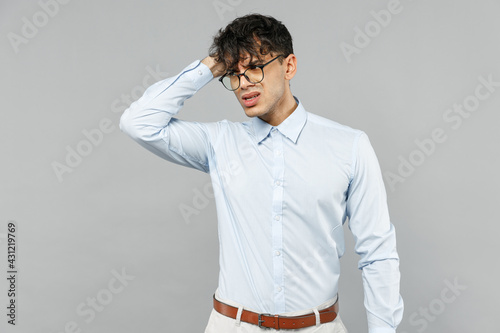 Young puzzled thoughtful sad employee business latin man 20s corporate lawyer wear classic white shirt glasses look aside scratch head isolated on grey background studio portrait Career achievement.