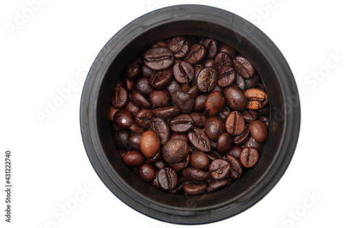 Grains of coffee in a coffee grinder on a white background