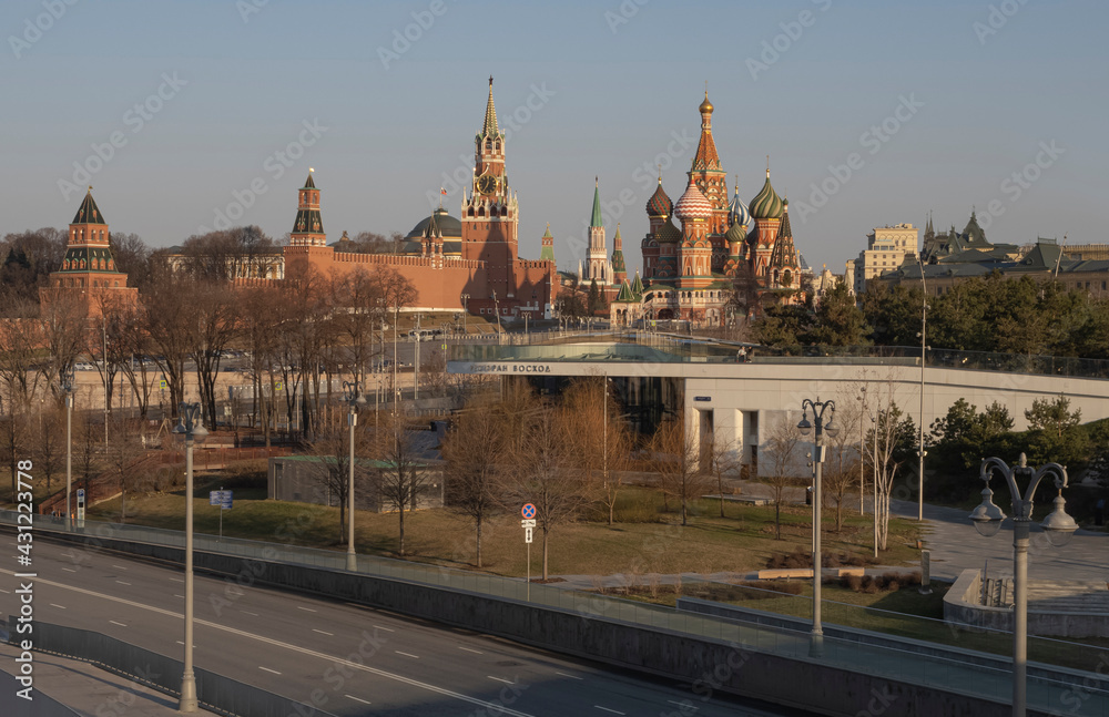View of the Moscow Kremlin from the bridge. Early morning. St. Basil's Cathedral and chimes. Road and park. Clear sky