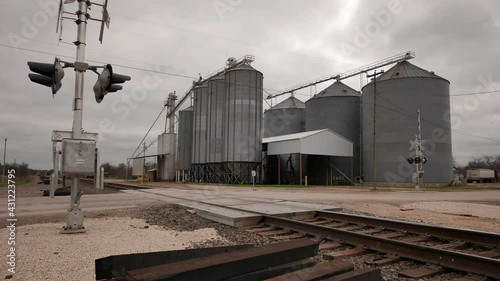 A grain silo in Crawford, Texas with railroad tracks in the foreground. photo