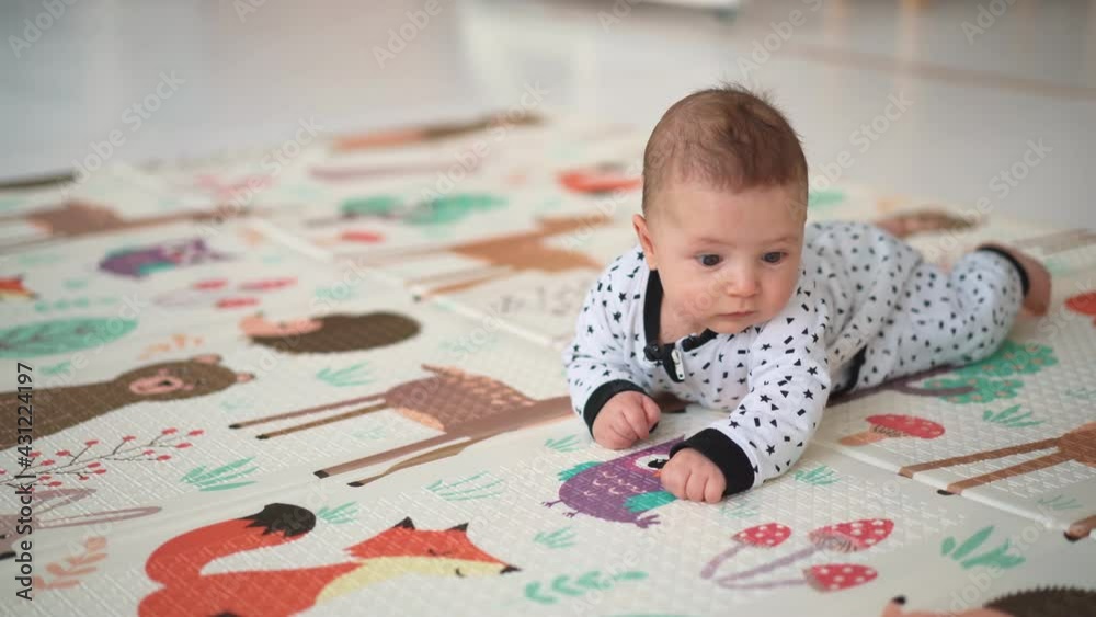 Baby first turn over exercise . Cute little baby turn on the belly on the mat. Baby first turn over exercise . Cute little baby turn on the belly on the mat.