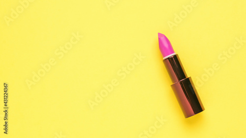 Stylish bright lipstick on a yellow background.
