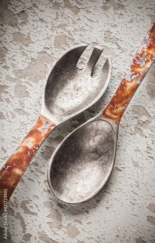 Two old metal spoons kitchen salad set on overhead arrangement old rustic wooden white table studio shot