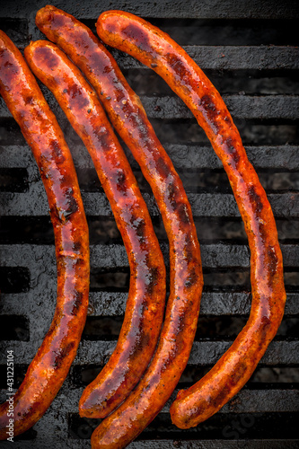 Grilled fresh sausages with barbecue marks vibrant color outdoor top down arrangement