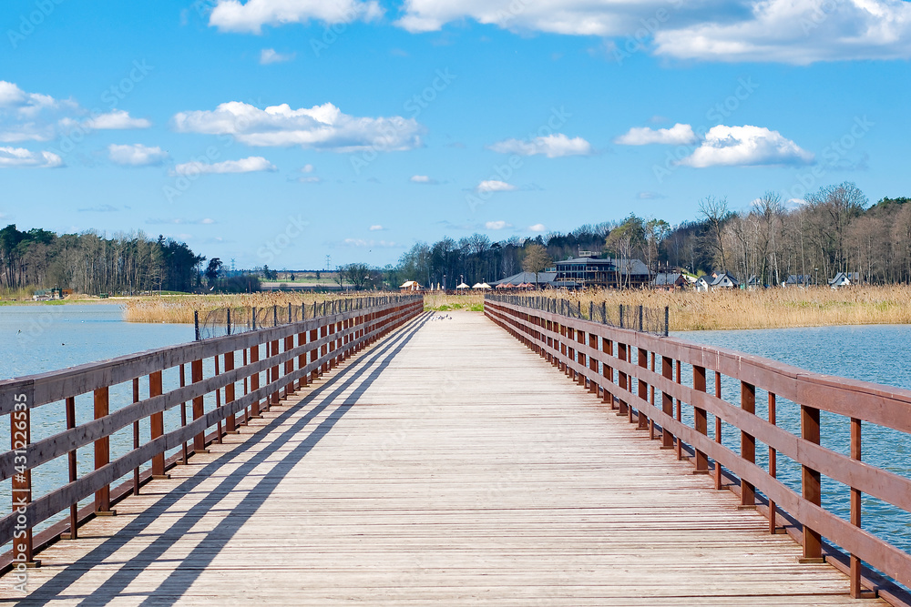 wooden bridge over the lake, beautiful blue sky with clouds