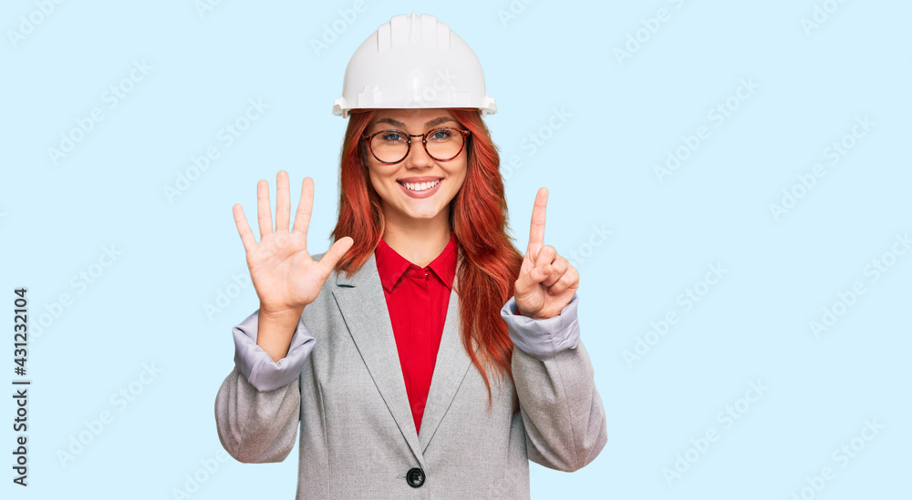 Young redhead woman wearing architect hardhat showing and pointing up with fingers number six while smiling confident and happy. Young redhead woman wearing architect hardhat showing and pointing up with fingers number six while smiling confident and happy.