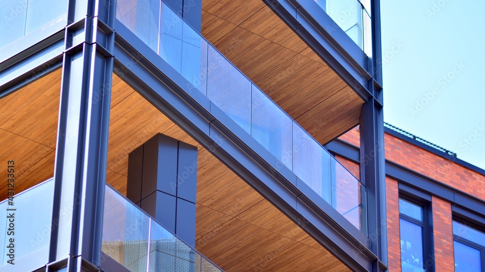 A fragment of the steel and glass metal facade of building. Detail architecture steel and glass facade on clear blue sky background. Modern architecture building facade with balconies. New apartments A fragment of the steel and glass metal facade of building. Detail architecture steel and glass facade on clear blue sky background. Modern architecture building facade with balconies. New apartments