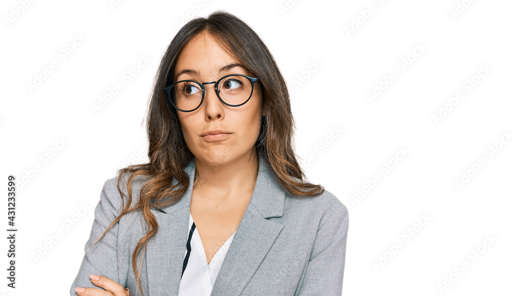 Young brunette woman wearing business clothes smiling looking to the side and staring away thinking. Young brunette woman wearing business clothes smiling looking to the side and staring away thinking.