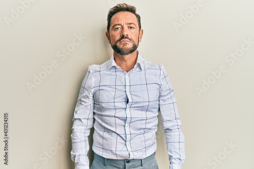 Middle age man wearing business clothes with serious expression on face. simple and natural looking at the camera. © Krakenimages.com