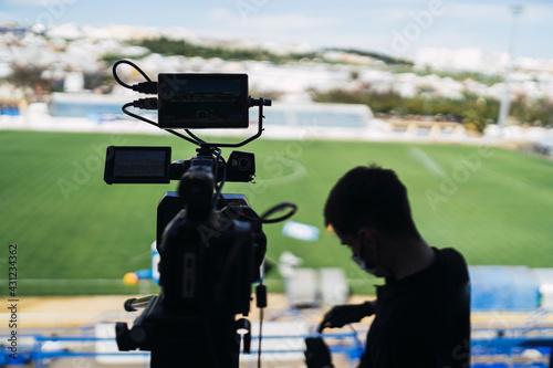Silueta de operadores de cámara con cámara en un partido de futbol photo