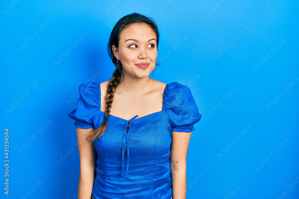 Young hispanic girl wearing casual clothes smiling looking to the side and staring away thinking. Young hispanic girl wearing casual clothes smiling looking to the side and staring away thinking.