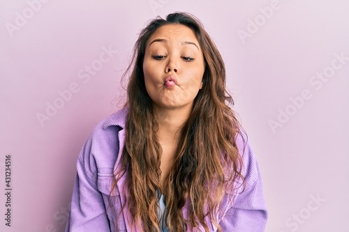 Young hispanic girl wearing casual clothes making fish face with lips  crazy and comical gesture. funny expression.