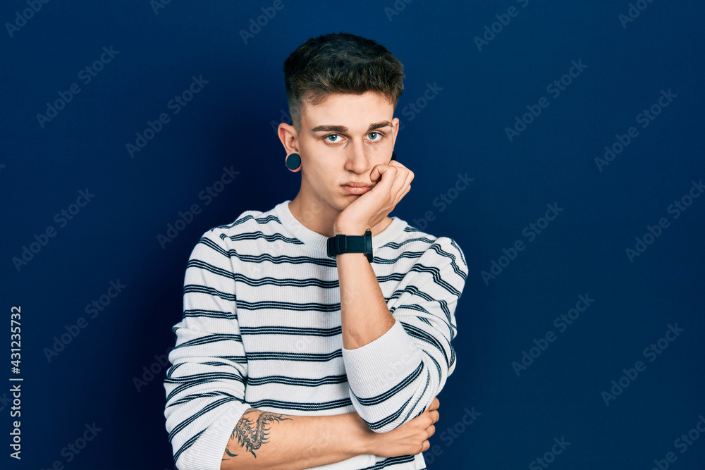 Young caucasian boy with ears dilation wearing casual striped shirt thinking looking tired and bored with depression problems with crossed arms. Young caucasian boy with ears dilation wearing casual striped shirt thinking looking tired and bored with depression problems with crossed arms.