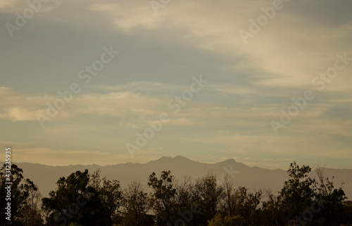 Sunset in the mountains.Landscape.Sunset.Forest.Mountains.Moutains landscape.Forest landscape.Sunset landscape.Forest full of trees during the sunset with the moutains shown behind the trees.
