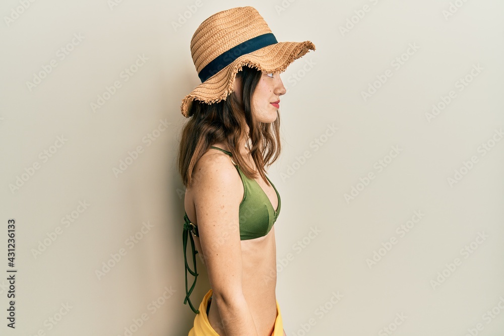 Young brunette woman wearing bikini looking to side, relax profile pose with natural face with confident smile. Young brunette woman wearing bikini looking to side, relax profile pose with natural face with confident smile.