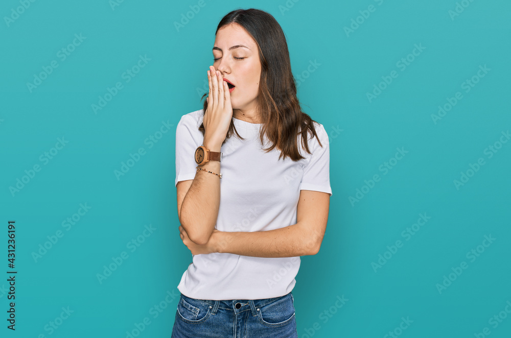 Young beautiful woman wearing casual white t shirt bored yawning tired covering mouth with hand. restless and sleepiness.