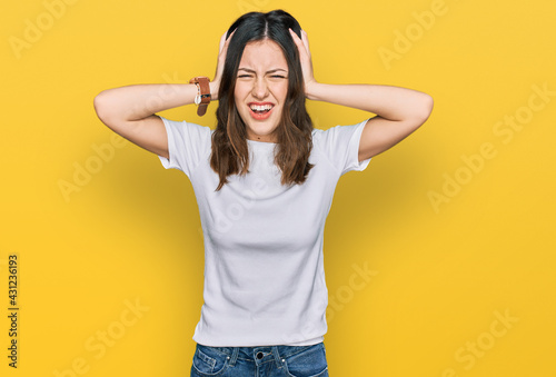 Young beautiful woman wearing casual white t shirt crazy and scared with hands on head, afraid and surprised of shock with open mouth