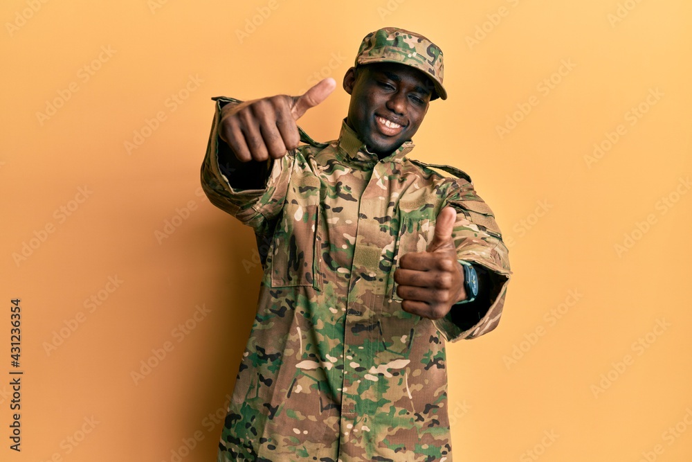 Young african american man wearing army uniform approving doing positive gesture with hand, thumbs up smiling and happy for success. winner gesture. Young african american man wearing army uniform approving doing positive gesture with hand, thumbs up smiling and happy for success. winner gesture.
