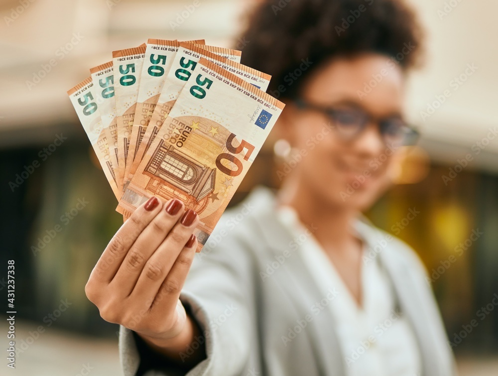 Young african american businesswoman holding 50 euro banknotes at the city. Young african american businesswoman holding 50 euro banknotes at the city.