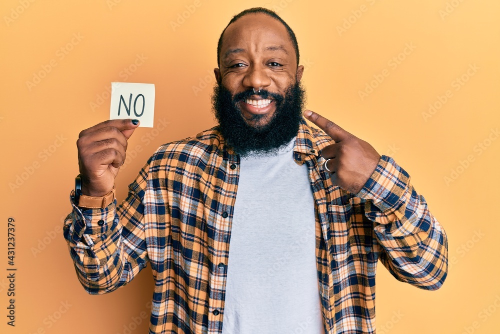 Young african american man holding no reminder smiling happy pointing with hand and finger Young african american man holding no reminder smiling happy pointing with hand and finger